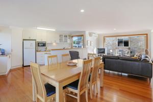 a kitchen and living room with a wooden table and chairs at LAKESIDE2 in Merimbula