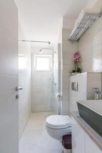 La salle de bains blanche est pourvue de toilettes et d'un lavabo. dans l'établissement Apartments with WiFi Split - 14594, à Split