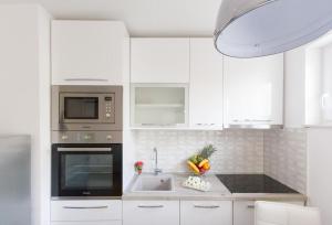 - une cuisine blanche avec évier et four micro-ondes dans l'établissement Apartments with WiFi Split - 14594, à Split