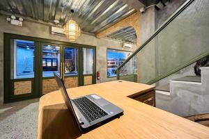 a laptop sitting on a wooden table in a room at Rattanhaus R Signature Mitra RedDoorz in Palembang