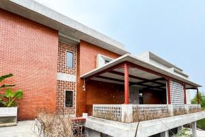 - un bâtiment en briques rouges avec une terrasse couverte dans l'établissement Rattanhaus R Signature Mitra RedDoorz, à Palembang