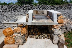a stone oven sitting on top of a pile of rocks at Secluded holiday house Milovcici, Krk - 14604 in Malinska