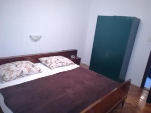 a bedroom with a bed with two pillows on it at Rooms with a parking space Lukovo, Senj - 14567 in Sveti Juraj +4 photos