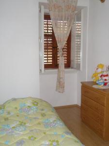een slaapkamer met een bed, een raam en een dressoir bij Apartments with WiFi Vodnjan, Fazana - 14650 in Vodnjan