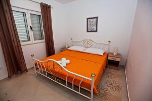 pomarańczowe łóżko w pokoju z oknem w obiekcie Apartments by the sea Pakostane, Biograd - 14658 w Pakoštane