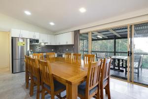 uma cozinha e sala de jantar com uma mesa de madeira e cadeiras em Jindalee Spa Lodge em Vacy