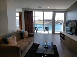 a living room with a couch and a television and a table at Apartment 3 Wallaroo Marina in Wallaroo