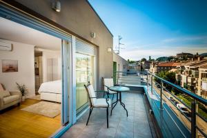 a balcony with a bed and a table on a balcony at Apartments and rooms with WiFi Zagreb - 14675 in Zagreb