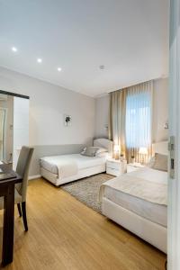 a bedroom with two beds and a desk and a table at Apartments and rooms with WiFi Zagreb - 14675 in Zagreb