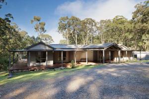 uma casa com um telhado de metal numa estrada em Jindalee Spa Lodge em Vacy