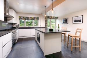 una cocina con armarios blancos y una gran isla en Lowfield House en Ambleside