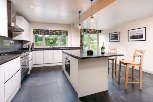 a kitchen with white cabinets and a large island at Lowfield House in Ambleside