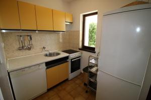 a kitchen with a white refrigerator and a sink at Apartments by the sea Sumartin, Brac - 14703 in Sumartin