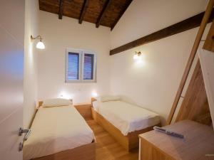 a room with two beds and a window at Holiday house with a swimming pool Preko, Ugljan - 14707 in Preko