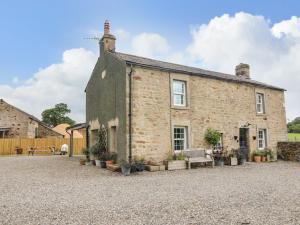 una vecchia casa di mattoni con una panchina davanti di Box Tree Farm House a Lancaster