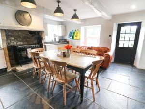 a kitchen and living room with a wooden table and chairs at Box Tree Farm House in Lancaster