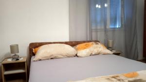 a bed with two pillows on it in a bedroom at Seaside holiday house Vinisce, Trogir - 14704 in Vinišće