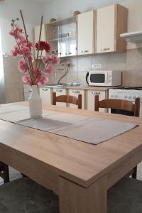 a kitchen with a table with a vase with flowers on it at Seaside holiday house Vinisce, Trogir - 14704 in Vinišće