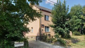 una casa con una puerta y árboles delante de ella en Ferienwohnung Beim Rößl, en Nossen