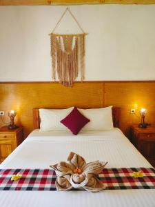 a bedroom with a bed with a flower on it at Grealeen Cottages in Nusa Penida