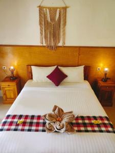 a bedroom with a bed with a flower on it at Grealeen Cottages in Nusa Penida