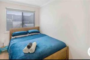 sypialnia z łóżkiem z ręcznikami i oknem w obiekcie Beach Cottage - Port Arthur w mieście Port Arthur
