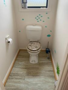 łazienka z toaletą w rogu pokoju w obiekcie Beach Cottage - Port Arthur w mieście Port Arthur