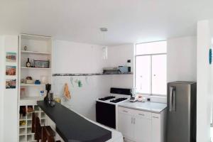 a white kitchen with a stove and a refrigerator at Departamentos Cerro Azul P1 in Cerro Azul