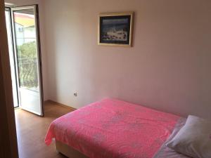 una camera con un letto e una coperta rosa di Apartments with a parking space Zdrelac, Pasman - 14734 a Ždrelac