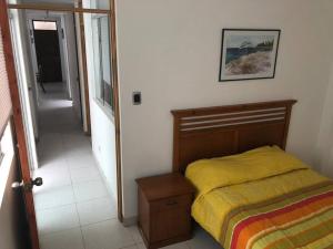 a bedroom with a bed with a yellow comforter at Departamentos Cerro Azul P1 in Cerro Azul