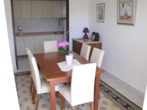 a dining room with a wooden table and white chairs at Apartments with a parking space Zadar - Diklo, Zadar - 14750 in Zadar