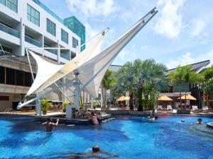 The Kee Resort & Spa في شاطيء باتونغ: مسبح في فندق فيه ناس في الماء