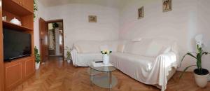 Apartments by the sea Supetar, Brac - 14747 في سوبيتار: غرفة معيشة بيضاء مع أريكة بيضاء وتلفزيون