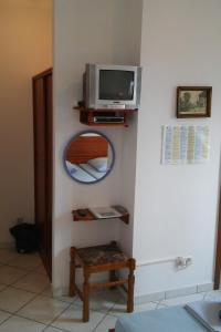 a room with a mirror and a tv on a wall at Double Room Stanici 14782a in Omiš