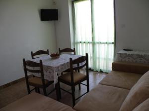 a dining room with a table and chairs and a couch at Apartments for families with children Pasman - 14788 in Mali Pašman