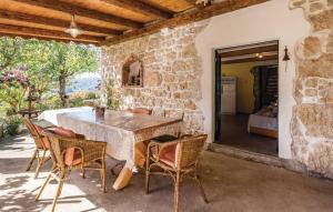 een stenen huis met een tafel en stoelen op een patio bij Holiday house with a parking space Supetarska Draga - Gornja, Rab - 14775 in Rab