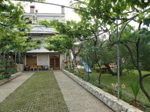 einen Garten mit einem Gehweg, der zu einem Haus führt in der Unterkunft Apartment Pasman 14788c in Mali Pašman