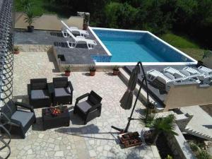 an overhead view of a swimming pool with chairs and a patio at Family friendly apartments with a swimming pool Tribalj, Crikvenica - 14789 in Tribalj
