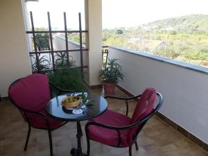 einen Tisch und Stühle mit einer Obstschale auf dem Balkon in der Unterkunft Apartment Pasman 14788b in Mali Pašman