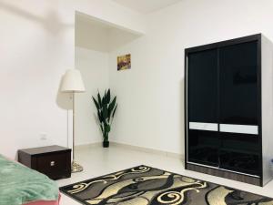 sala de estar con TV de pantalla plana grande en Alyn Homestay Batu Pahat IV Netflix, en Batu Pahat