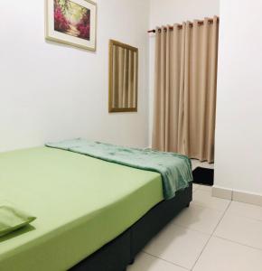 a bedroom with a green bed and a curtain at Alyn Home Batu Pahat IV Wifi Cuckoo in Batu Pahat