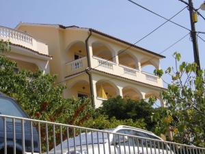 a large yellow building with a balcony on it at Apartment Lopar 14804a in Lopar