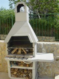 a pizza oven with a clock on top of it at Apartment Lopar 14804a in Lopar