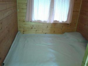 帕什曼的住宿－Secluded fisherman's cottage Cove Komornik, Pasman - 14801，木制客房的一张床位,设有窗户