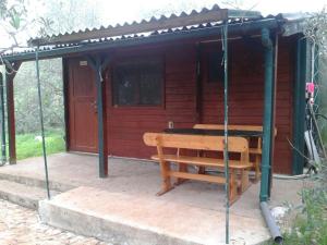 a wooden cabin with a bench in front of it at Secluded fisherman's cottage Cove Komornik, Pasman - 14801 in Pašman