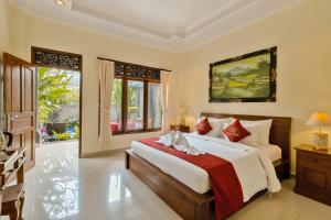 a bedroom with a large bed with a red blanket at Gora House Bali in Ubud