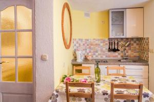 a kitchen with a table with a bottle of wine on it at Apartments by the sea Vrbnik, Krk - 14806 in Vrbnik