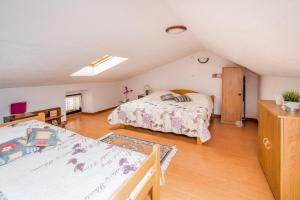 a attic bedroom with two beds and a skylight at Apartments by the sea Vrbnik, Krk - 14806 in Vrbnik