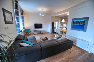 a living room with a black couch and a table at Holiday house with a swimming pool Hreljin, Kraljevica - 14813 in Hreljin
