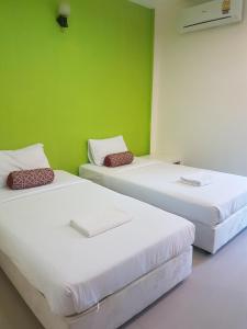 three beds in a room with a green wall at Life&Love Resort in Ban Khlong Son